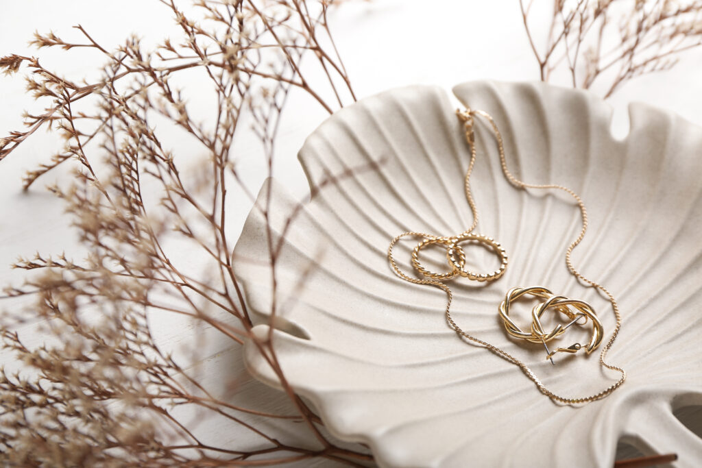plate with stylish accessories on light background, closeup